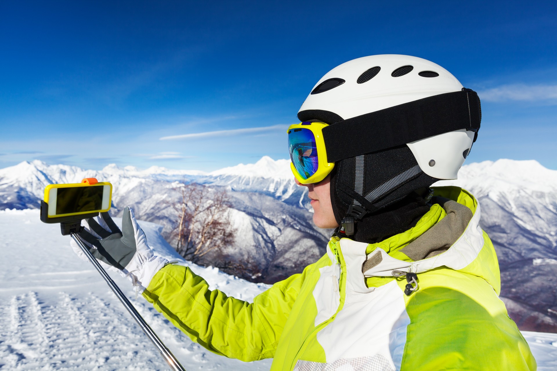 Woman with selfie stick on the mountain